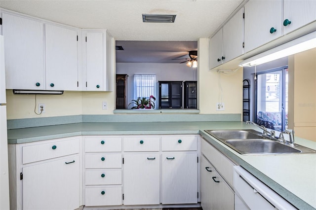 kitchen featuring ceiling fan, dishwasher, a textured ceiling, sink, and white cabinets