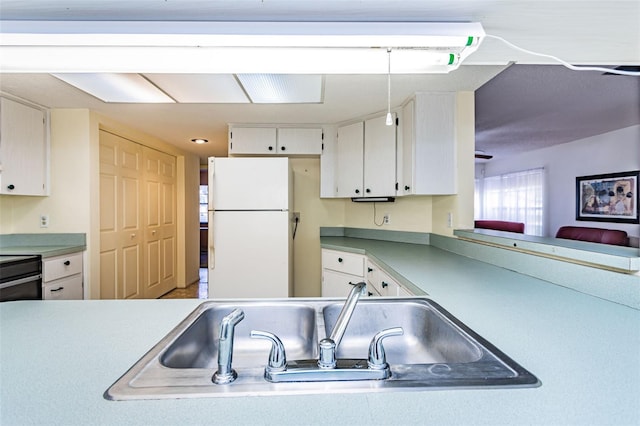 kitchen featuring white cabinets, white fridge, and sink