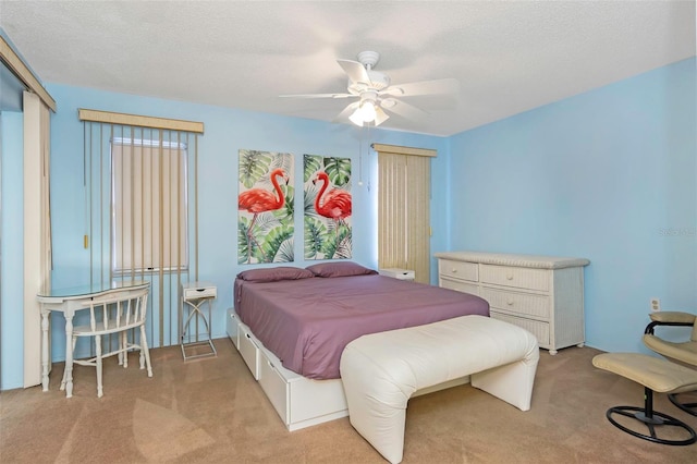 carpeted bedroom featuring ceiling fan and a textured ceiling