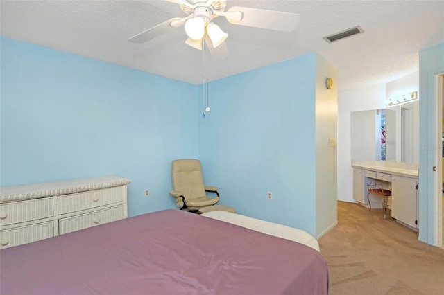 bedroom featuring a textured ceiling, ceiling fan, and light colored carpet