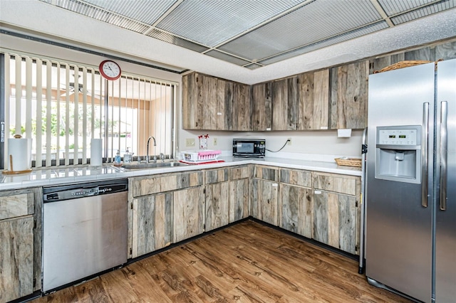 kitchen featuring appliances with stainless steel finishes, dark wood-type flooring, and sink