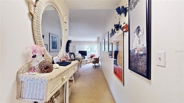 hallway featuring light carpet and a textured ceiling