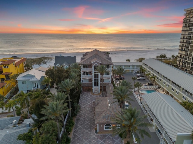 aerial view at dusk featuring a water view