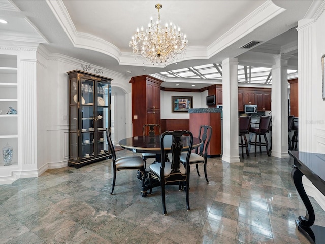 tiled dining room featuring a chandelier, crown molding, a raised ceiling, and ornate columns