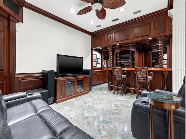 living room with ceiling fan, decorative columns, indoor bar, light tile flooring, and ornamental molding