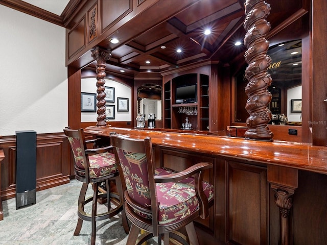 bar with ornamental molding, wooden counters, coffered ceiling, light tile flooring, and beam ceiling