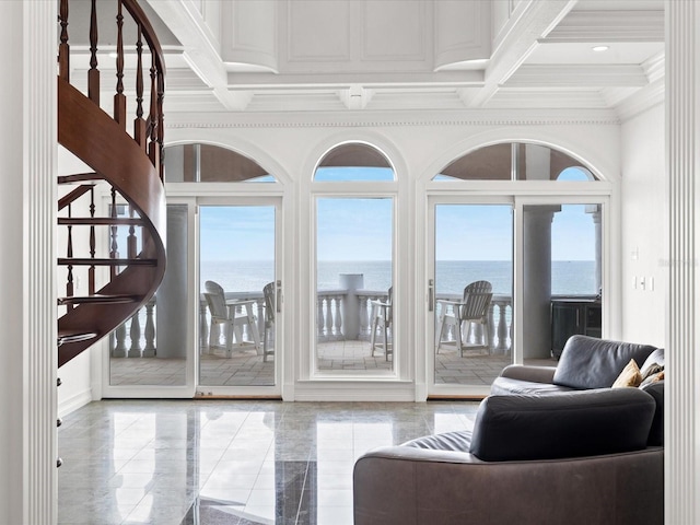 living room with a water view, coffered ceiling, a healthy amount of sunlight, and light tile floors