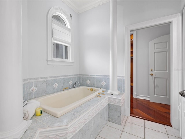 bathroom with a relaxing tiled bath, tile flooring, crown molding, and ornate columns