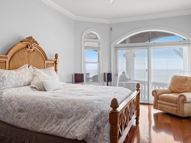 bedroom featuring crown molding, dark hardwood / wood-style floors, and multiple windows