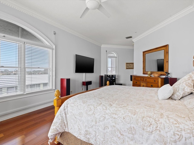 bedroom with ceiling fan, crown molding, and dark wood-type flooring