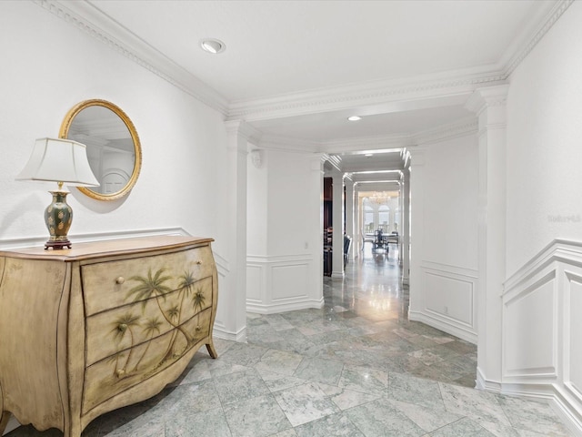 hallway with light tile flooring, decorative columns, and crown molding