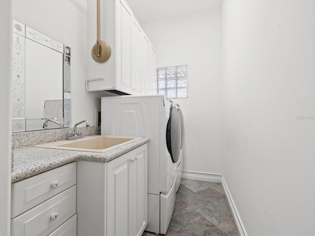 washroom featuring light tile flooring, sink, washing machine and dryer, and cabinets