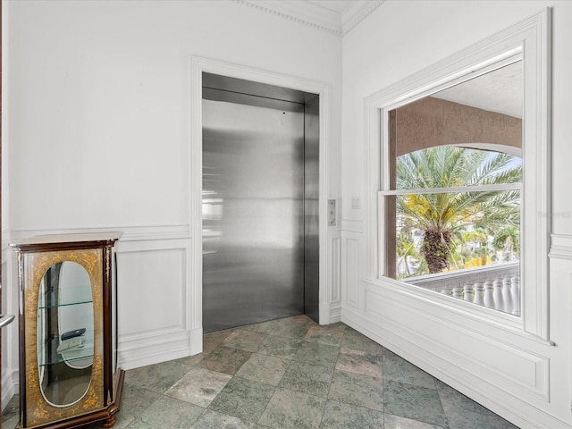 interior space with dark tile floors, elevator, and crown molding