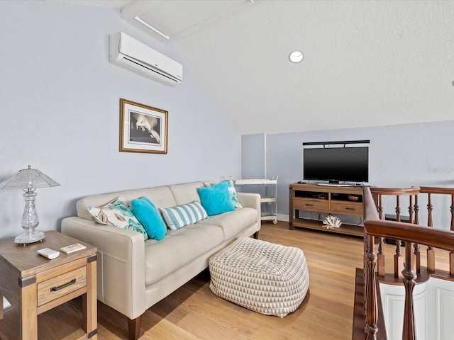 living room featuring light wood-type flooring, a wall mounted air conditioner, and vaulted ceiling