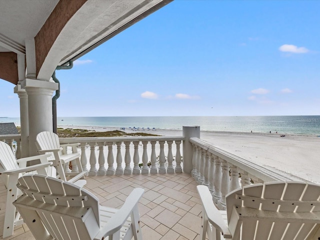 balcony with a water view and a beach view