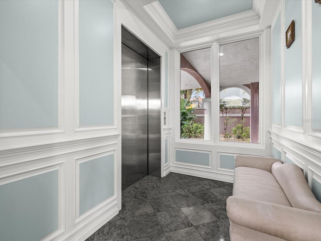 interior space with dark tile floors, elevator, a textured ceiling, and ornamental molding