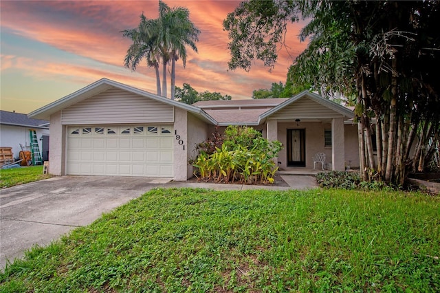 ranch-style home with a garage and a yard