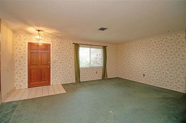 carpeted empty room with ornamental molding and a textured ceiling