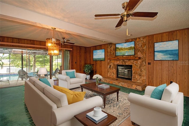 living room featuring beam ceiling, wooden walls, carpet floors, a fireplace, and a textured ceiling