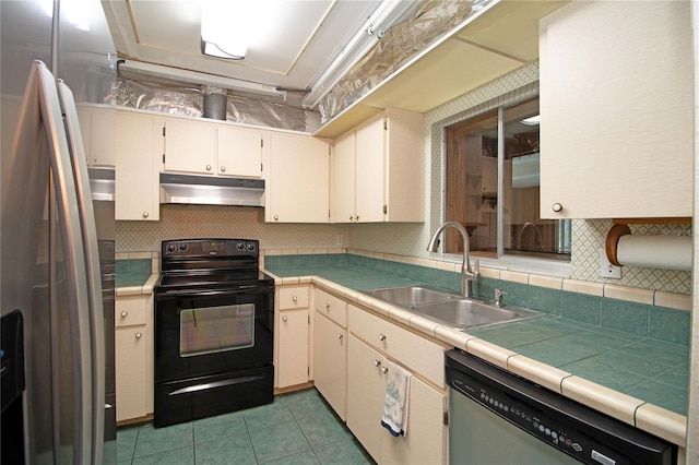 kitchen featuring sink, tile countertops, light tile patterned floors, appliances with stainless steel finishes, and decorative backsplash