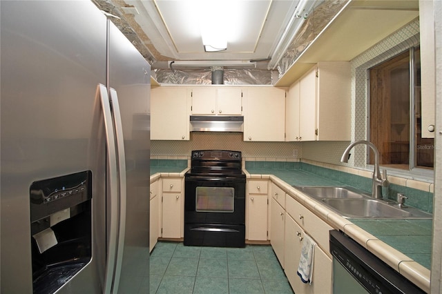 kitchen featuring sink, appliances with stainless steel finishes, tasteful backsplash, light tile patterned flooring, and cream cabinetry