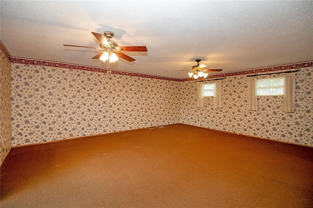 carpeted empty room featuring ceiling fan and a textured ceiling