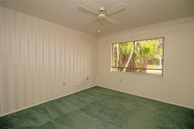 empty room with ceiling fan, a textured ceiling, and carpet