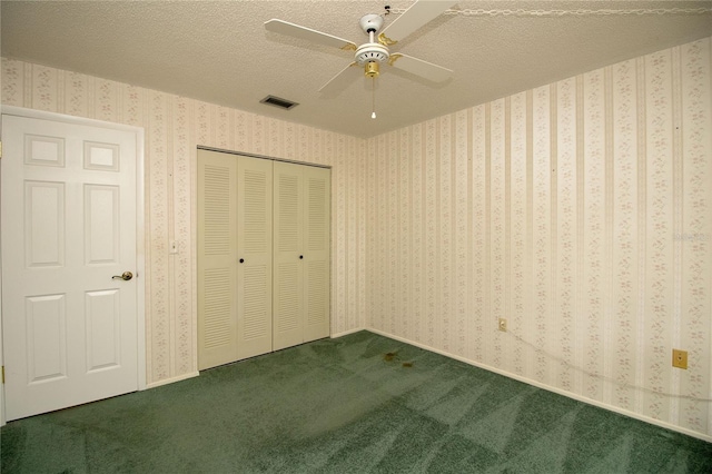 unfurnished bedroom featuring ceiling fan, a closet, carpet floors, and a textured ceiling