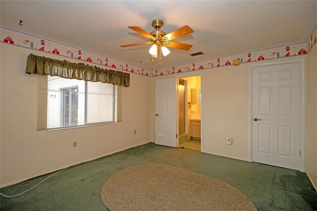 unfurnished bedroom with ensuite bathroom, a textured ceiling, and carpet flooring