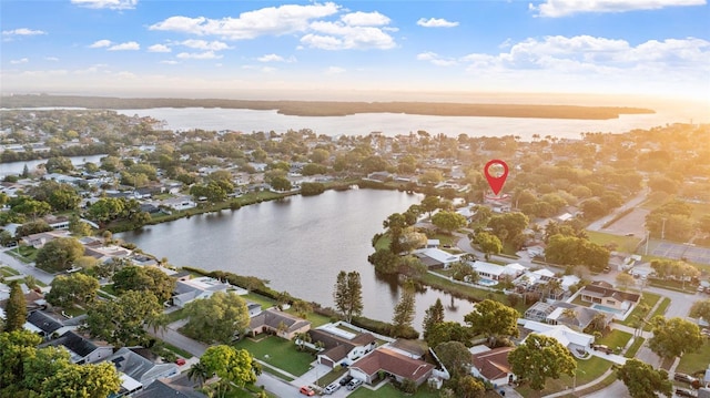 aerial view at dusk featuring a water view