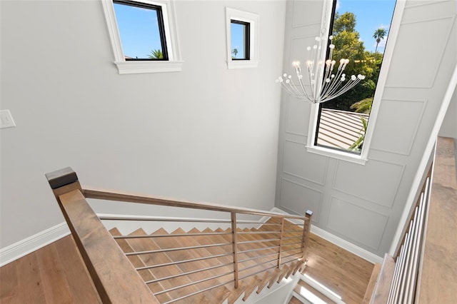 stairway featuring hardwood / wood-style flooring and a chandelier