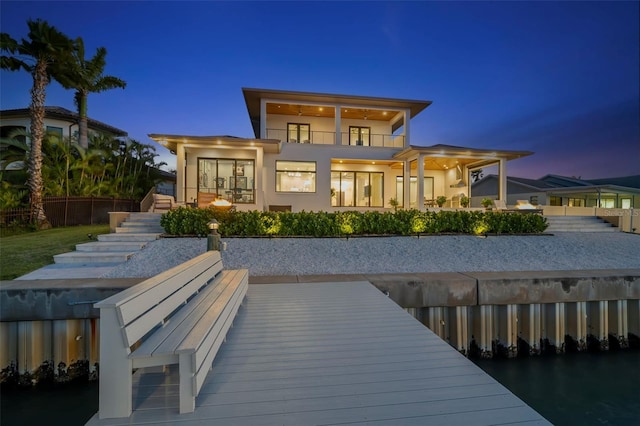 back house at dusk with a balcony