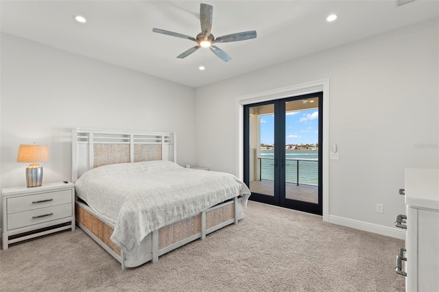 bedroom with light carpet, french doors, access to outside, a water view, and ceiling fan