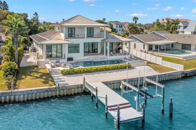 back of house featuring a balcony, a patio area, and a water view