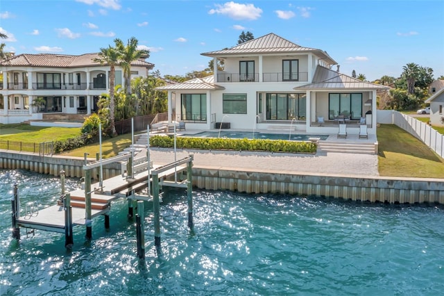 rear view of house with a balcony, a water view, and a patio