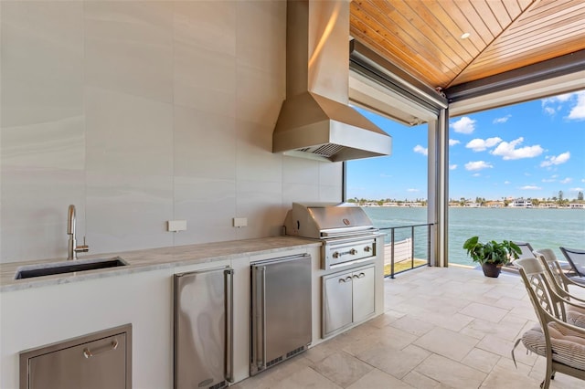 view of patio / terrace with sink, a water view, and area for grilling