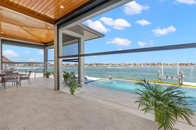 view of patio / terrace with pool water feature and a water view