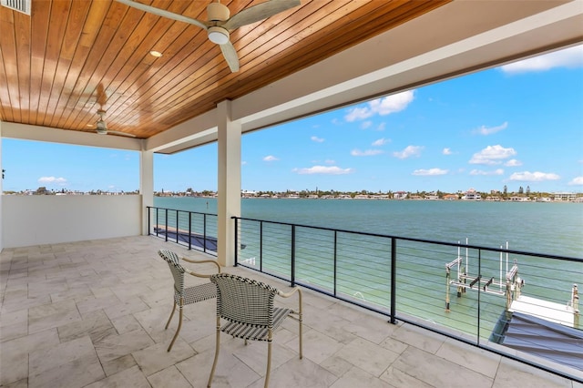 view of patio featuring a balcony, a water view, and ceiling fan