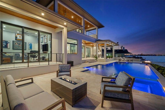 view of swimming pool with an in ground hot tub, a patio, and an outdoor living space with a fire pit