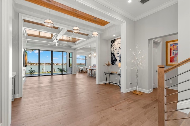 interior space with a water view, beamed ceiling, ornamental molding, and light hardwood / wood-style floors