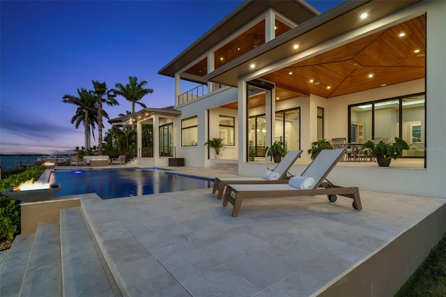 pool at dusk featuring a patio area