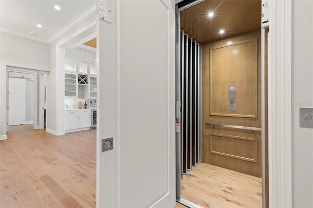 interior space featuring ornamental molding, elevator, hardwood / wood-style floors, and wine cooler