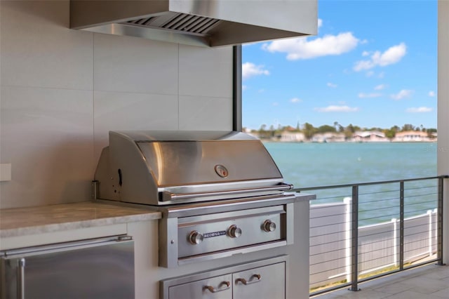 view of patio / terrace with area for grilling, an outdoor kitchen, and a water view