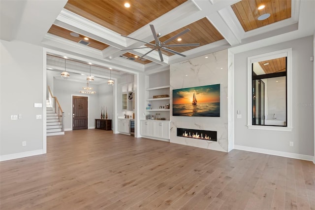 unfurnished living room featuring beamed ceiling, a high end fireplace, wooden ceiling, coffered ceiling, and built in shelves