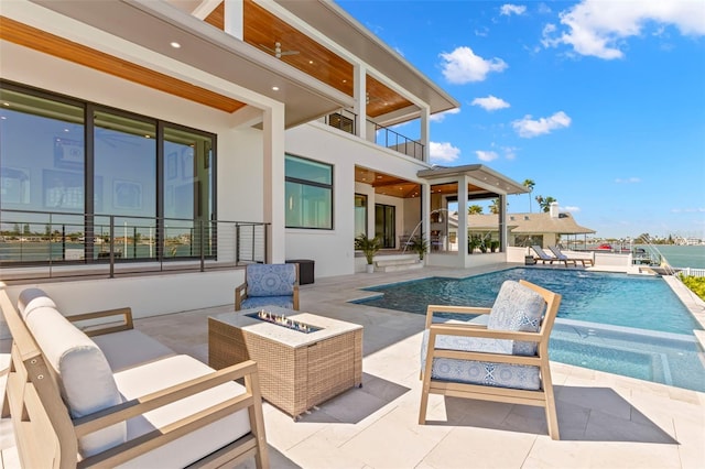 view of pool with an outdoor fire pit and a patio