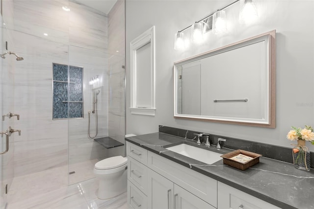 bathroom featuring toilet, a shower with shower door, and vanity