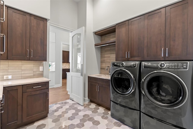 washroom with sink, cabinets, and independent washer and dryer