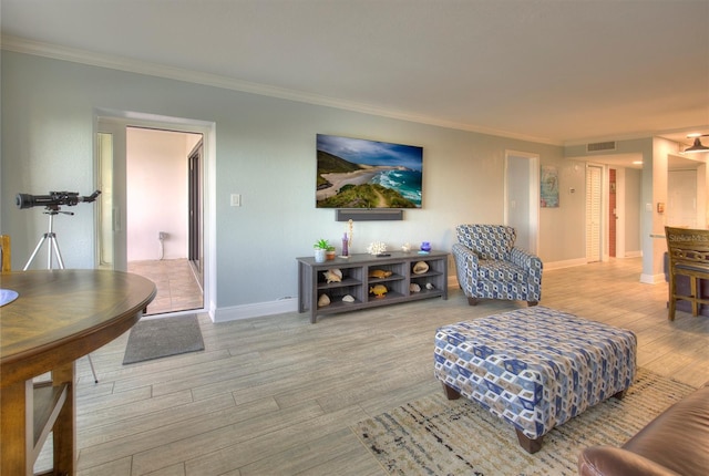 living room with crown molding and light hardwood / wood-style flooring