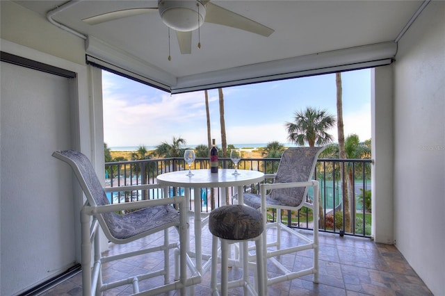 sunroom / solarium with ceiling fan, a water view, and a healthy amount of sunlight