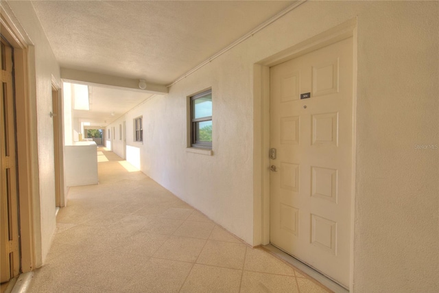 hall featuring a textured ceiling